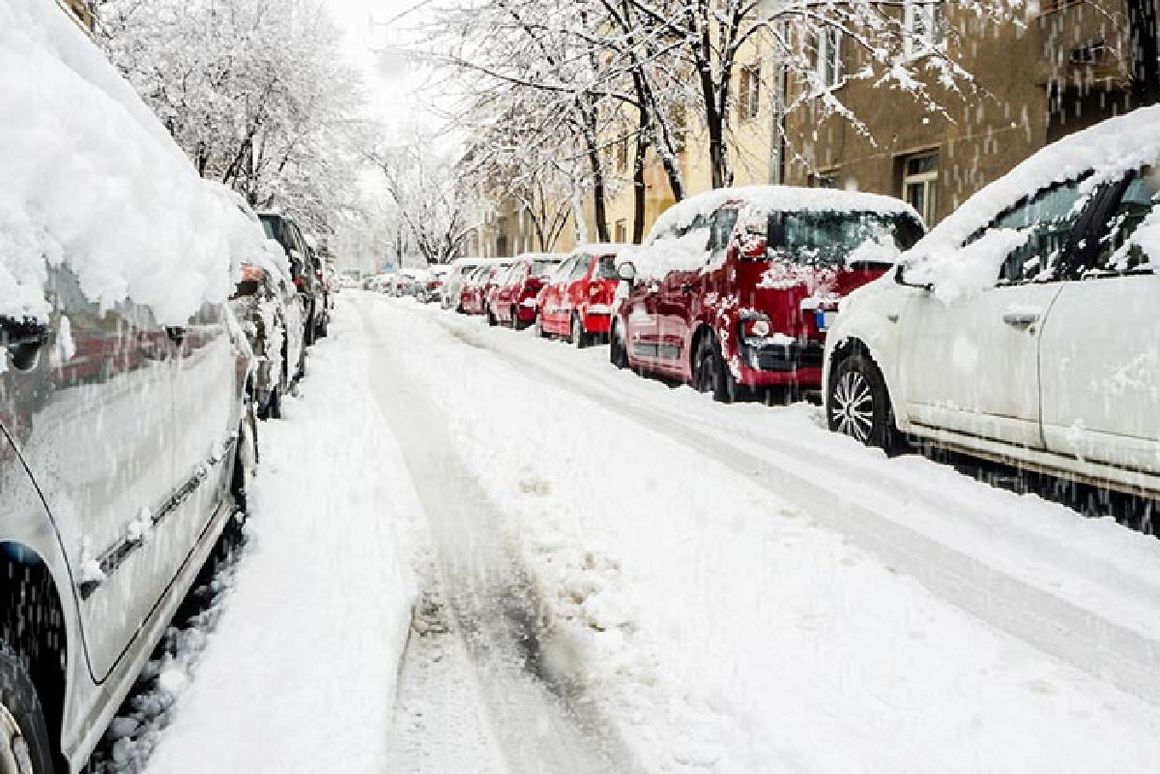 Parkende Autos an Straße mit Schnee